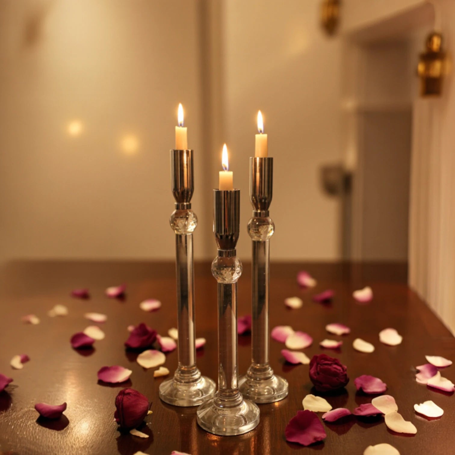 Set of three silver chrome candle holders with crystal stems and clear round bases arranged at varying heights