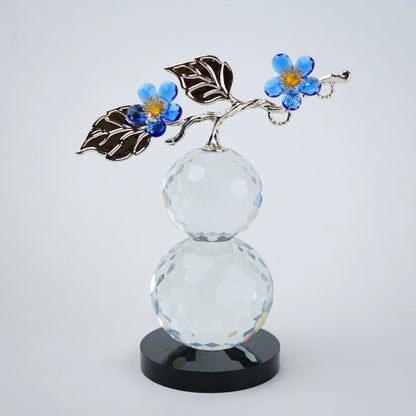 clear crystal decorative piece with floral detailing and metal leaves