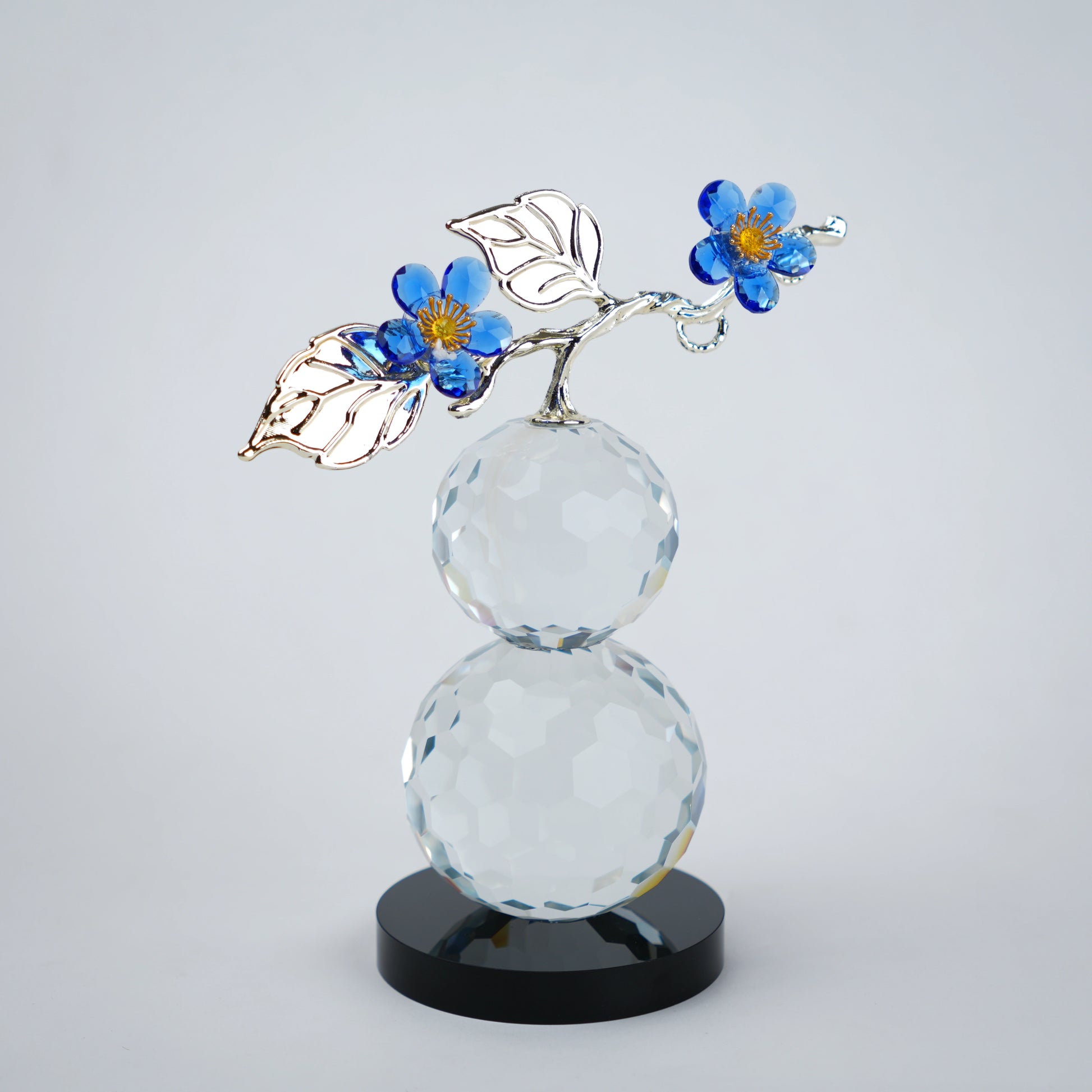 clear crystal decorative piece with floral detailing and metal leaves