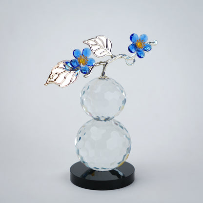 clear crystal decorative piece with floral detailing and metal leaves