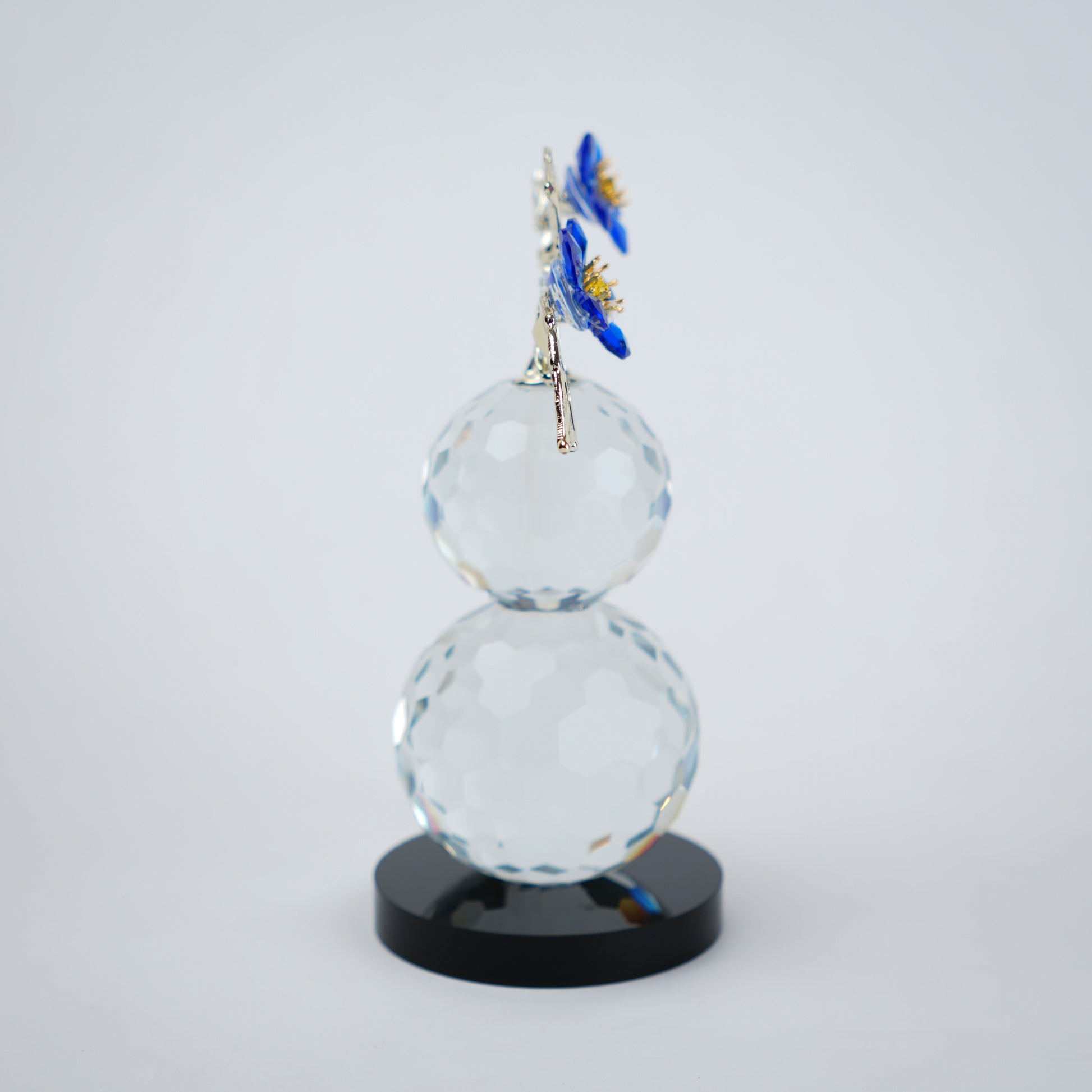 clear crystal decorative piece with floral detailing and metal leaves