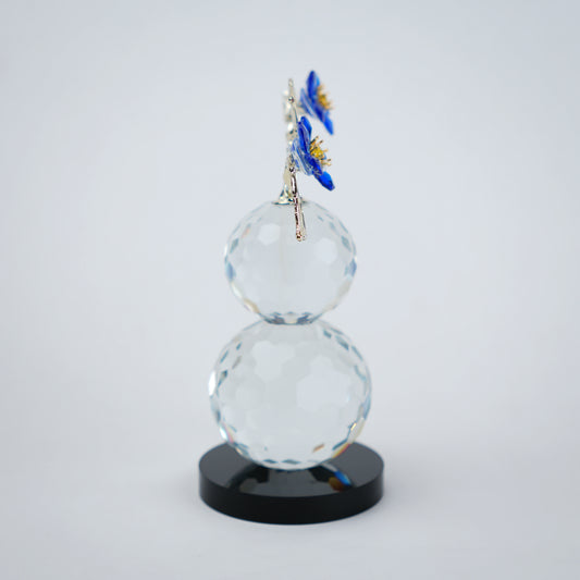 clear crystal decorative piece with floral detailing and metal leaves