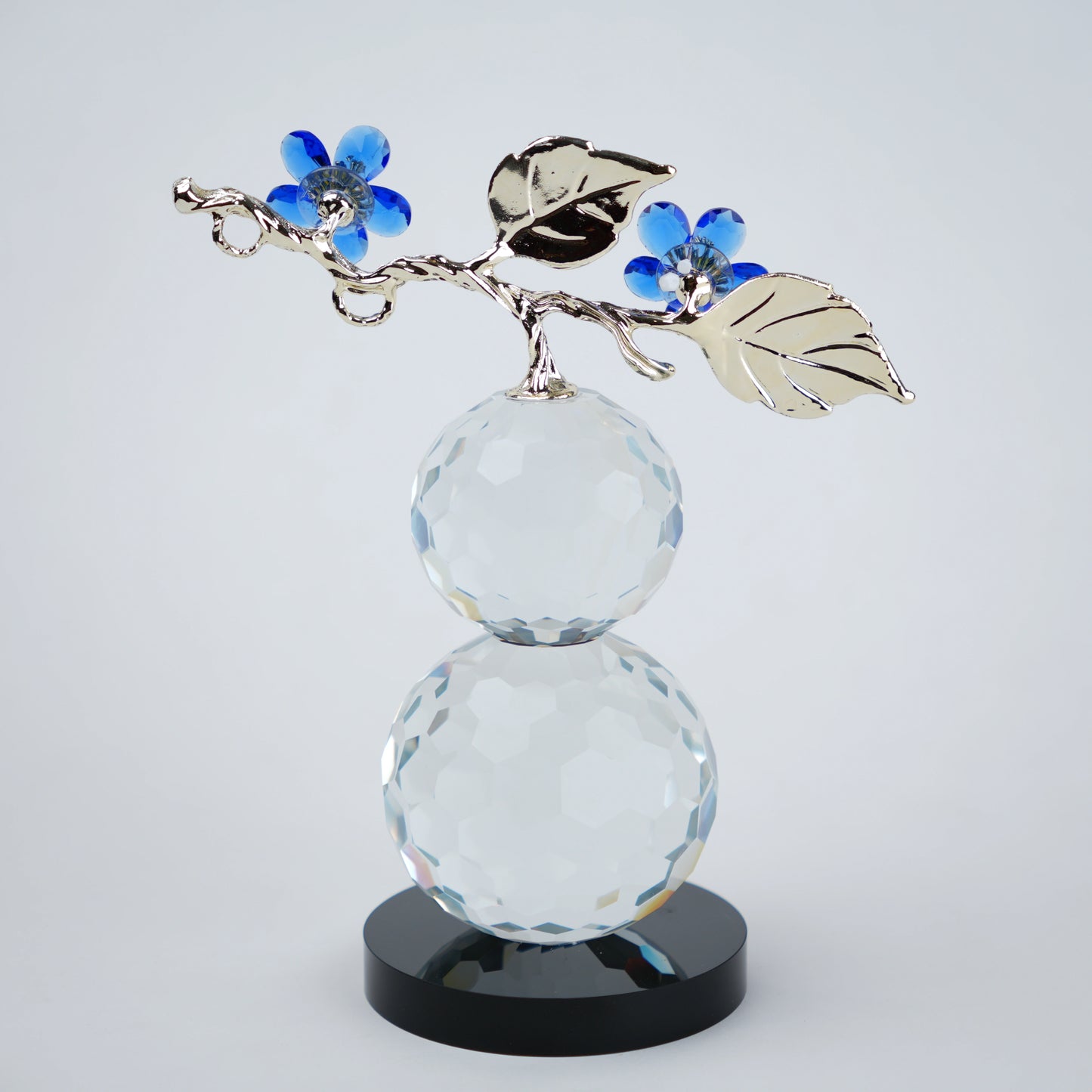 clear crystal decorative piece with floral detailing and metal leaves