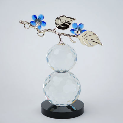 clear crystal decorative piece with floral detailing and metal leaves