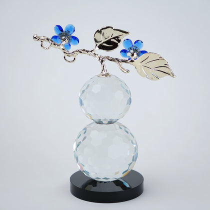 clear crystal decorative piece with floral detailing and metal leaves
