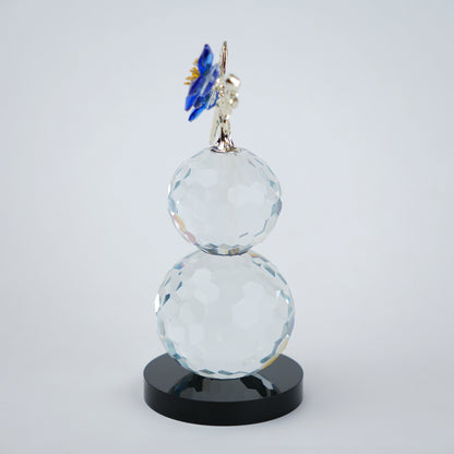 clear crystal decorative piece with floral detailing and metal leaves