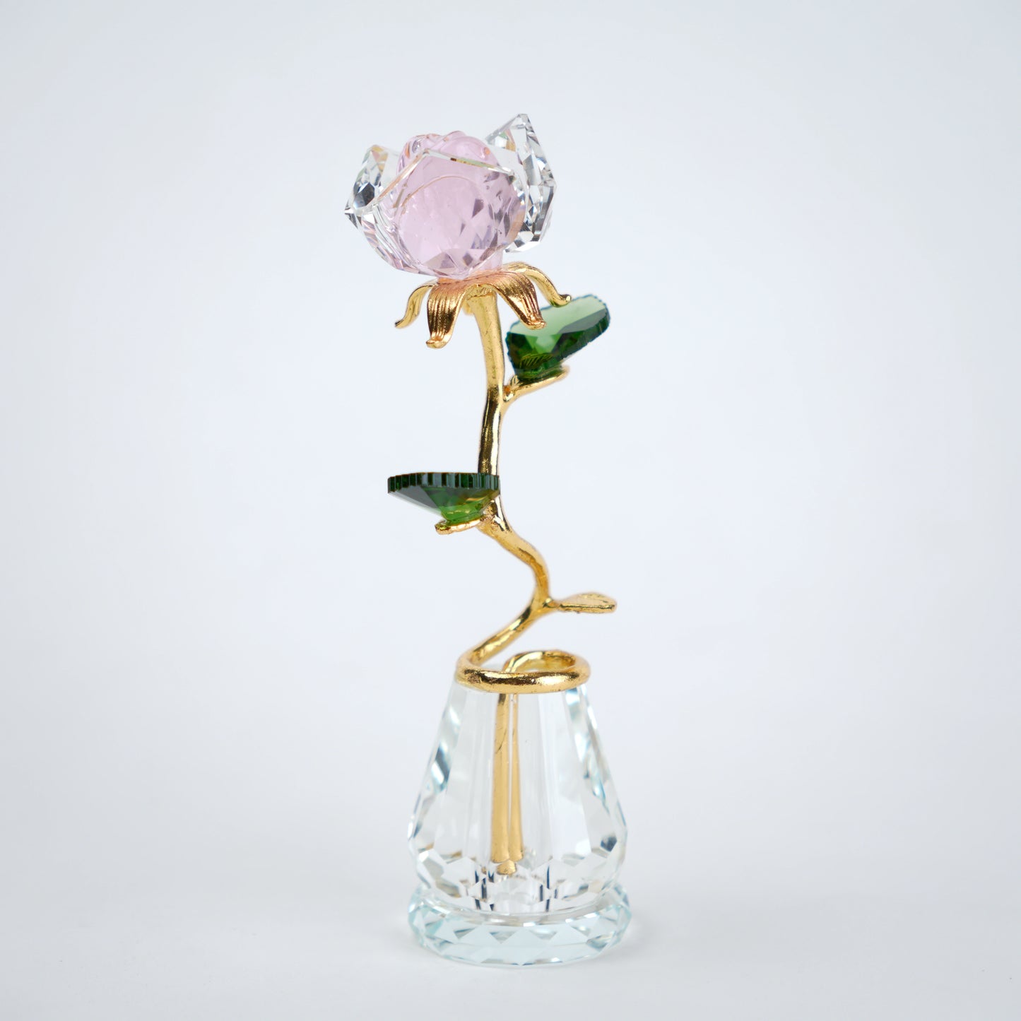 Decorative glass rose with pink gemstone on a white background