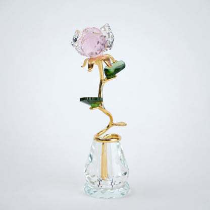 Decorative glass rose with pink gemstone on a white background