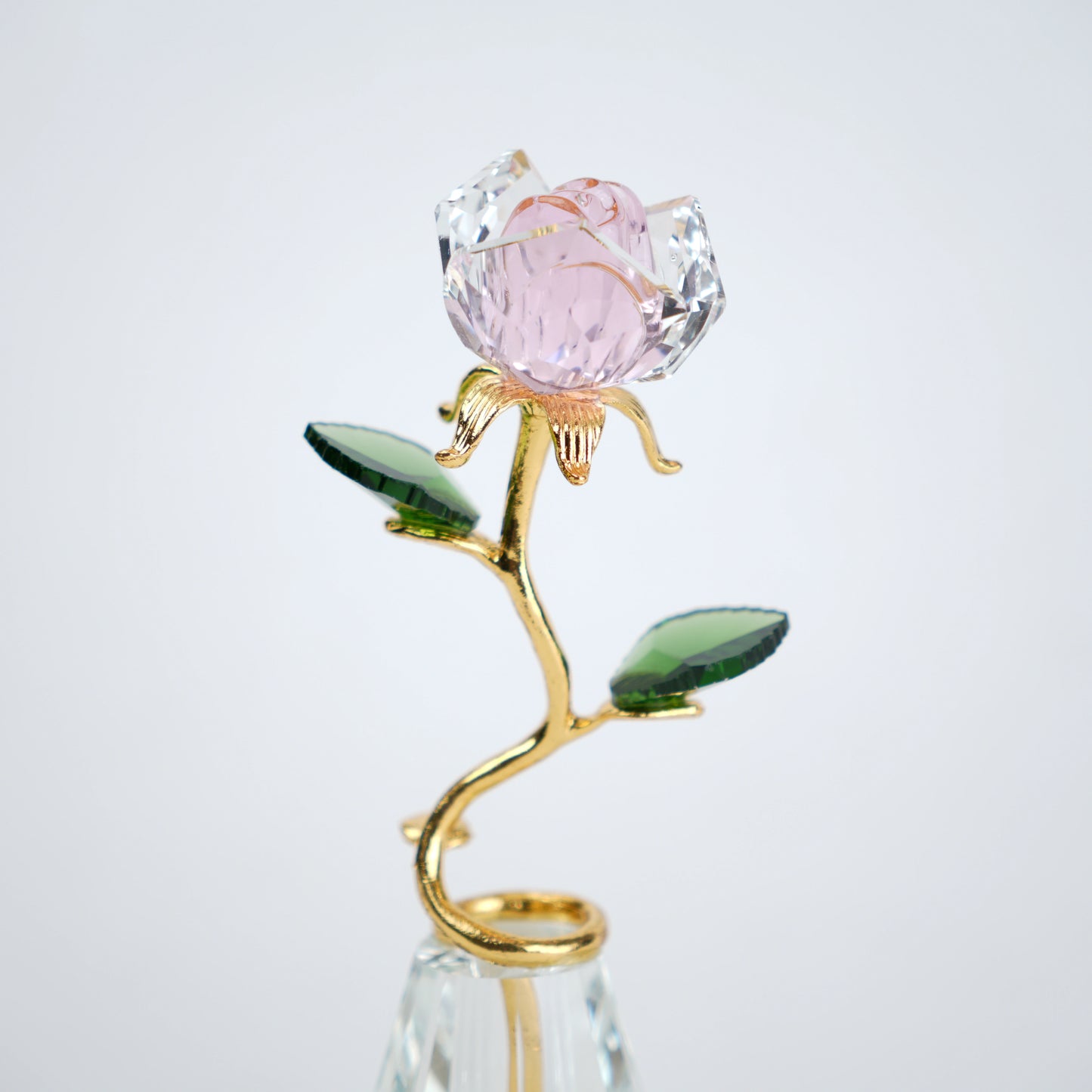 Decorative crystal flower with pink petal and gold stem on a white background