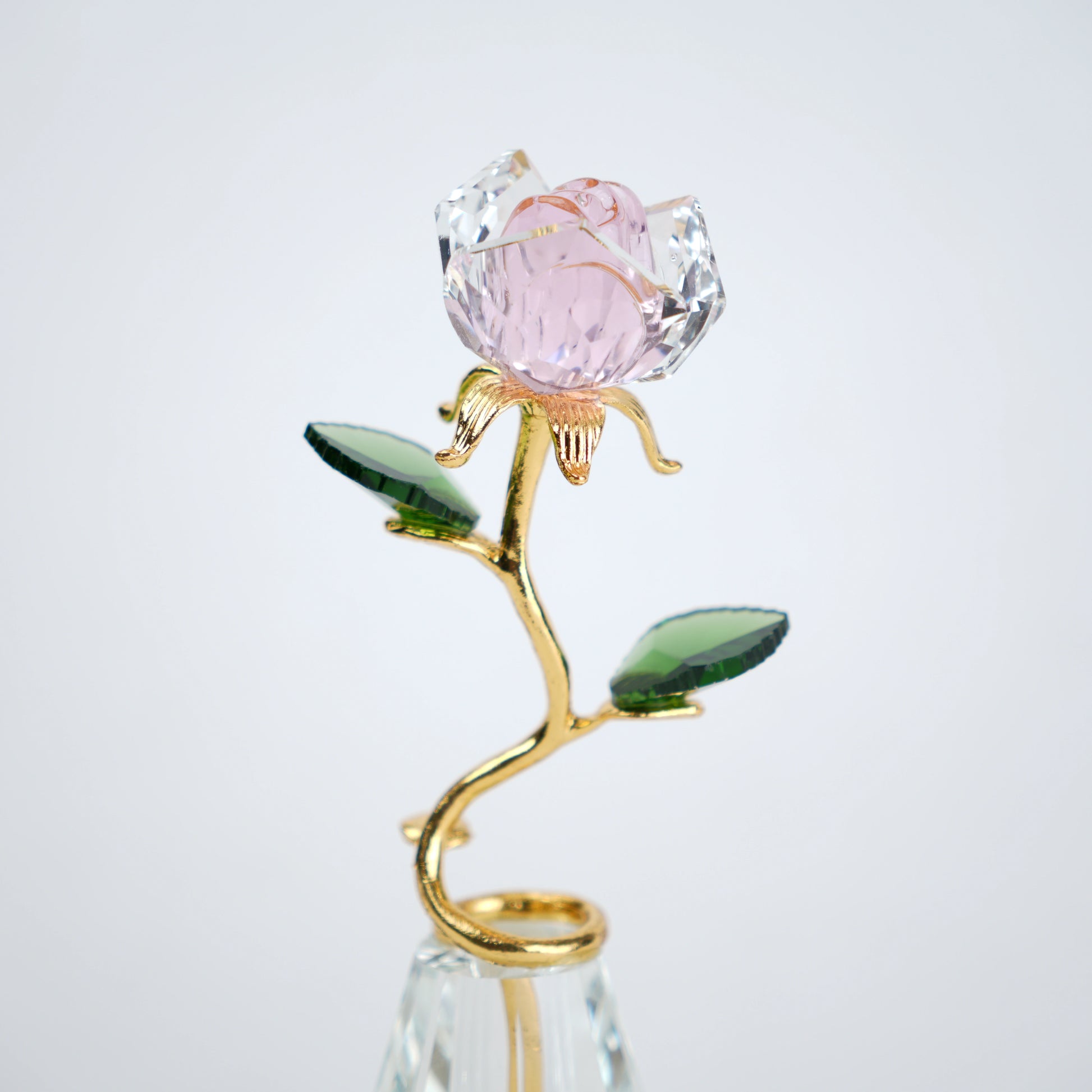 Decorative crystal flower with pink petal and gold stem on a white background