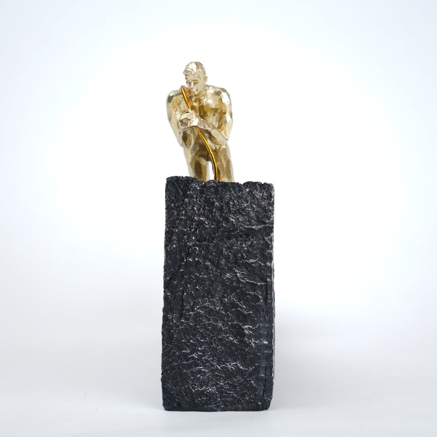 Gold climber figurine planting flag on textured stone incline base in black and white variants