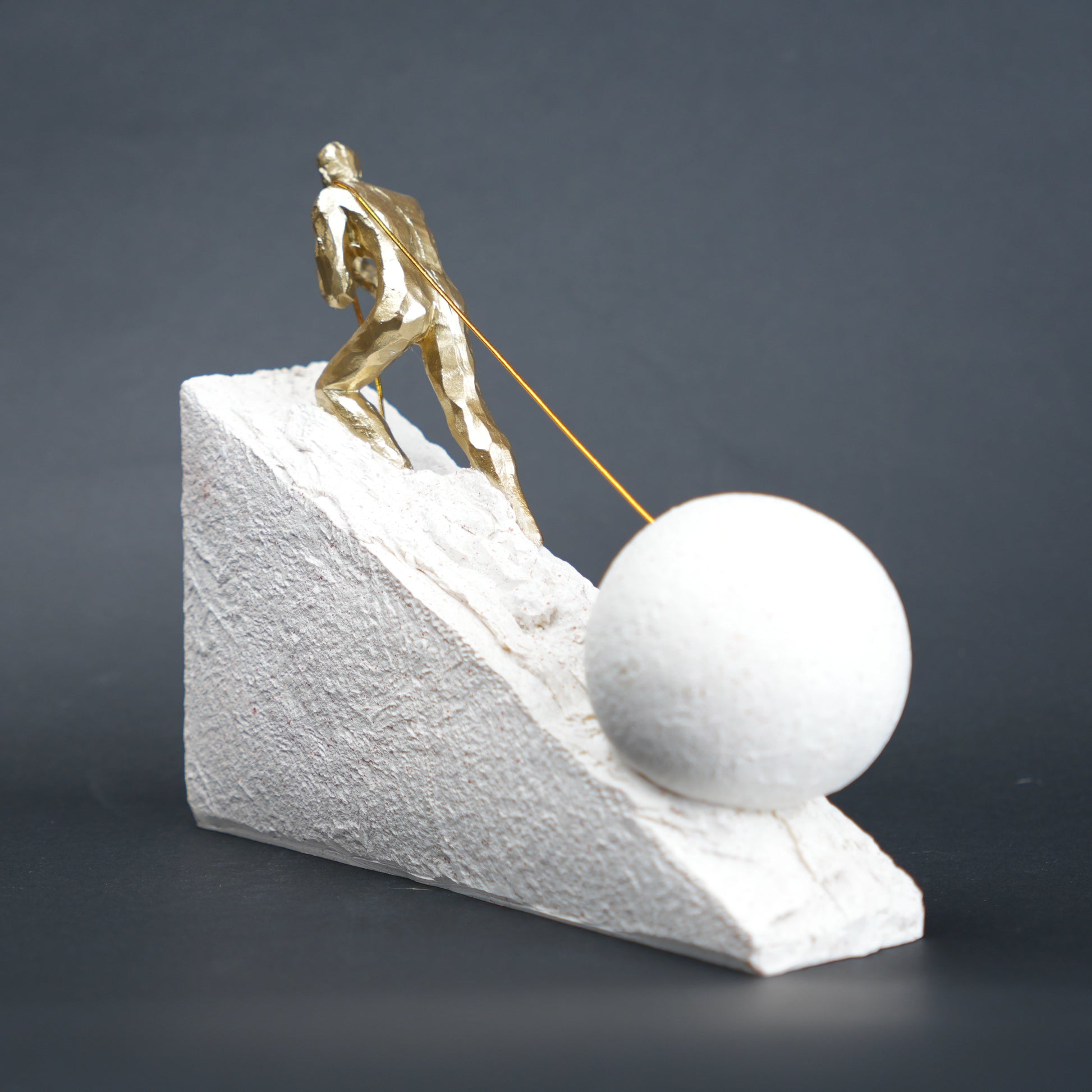 Gold climber figurine planting flag on textured stone incline base in black and white variants