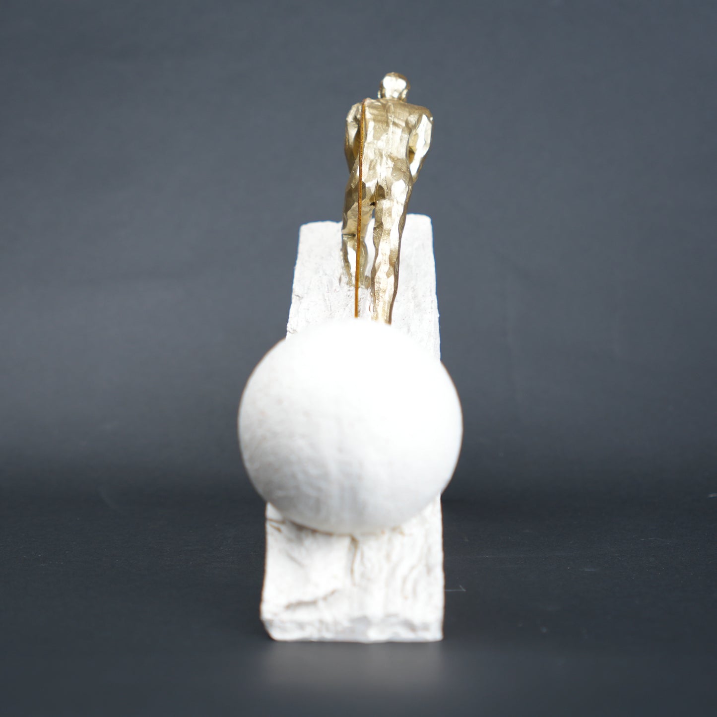 Gold climber figurine planting flag on textured stone incline base in black and white variants
