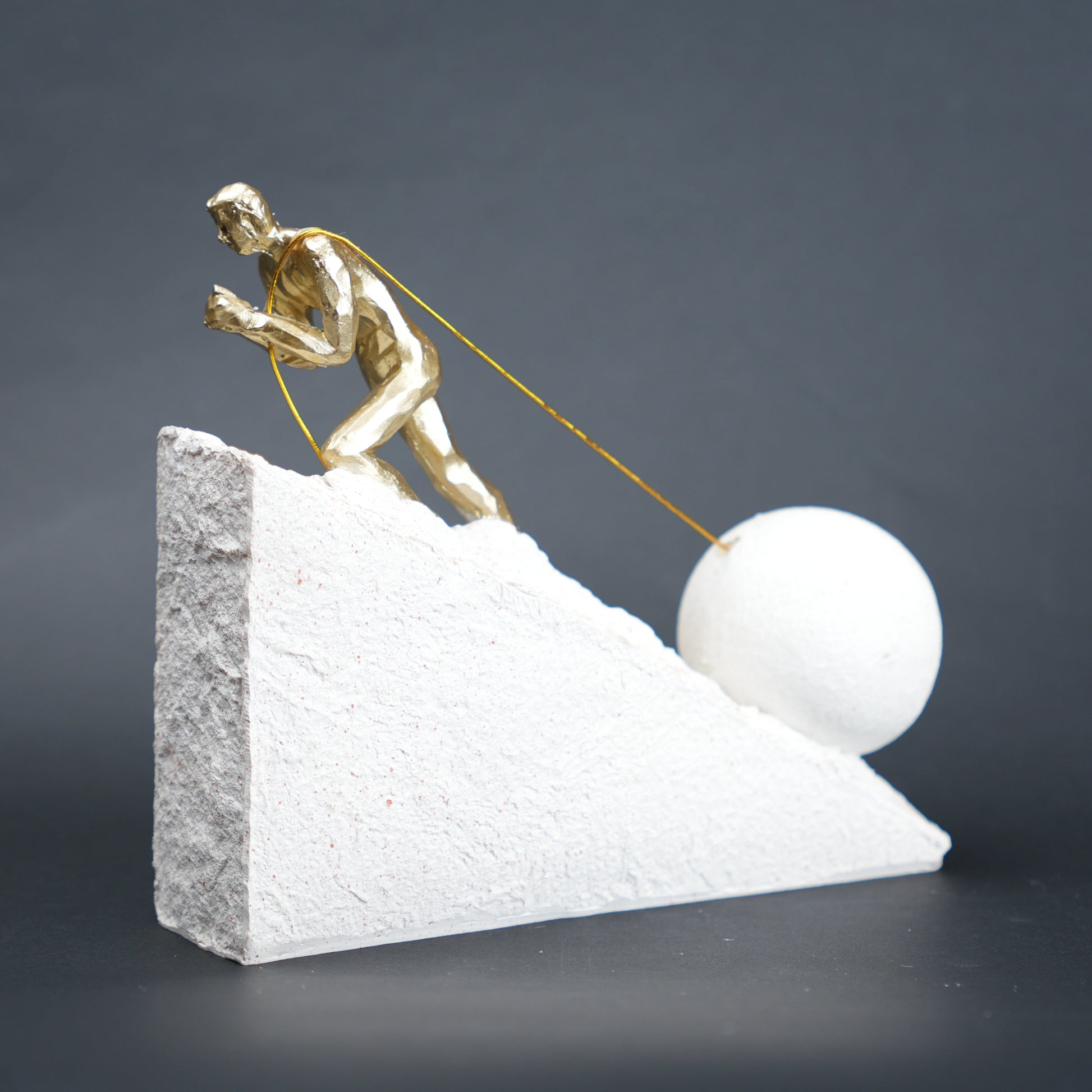 Gold climber figurine planting flag on textured stone incline base in black and white variants