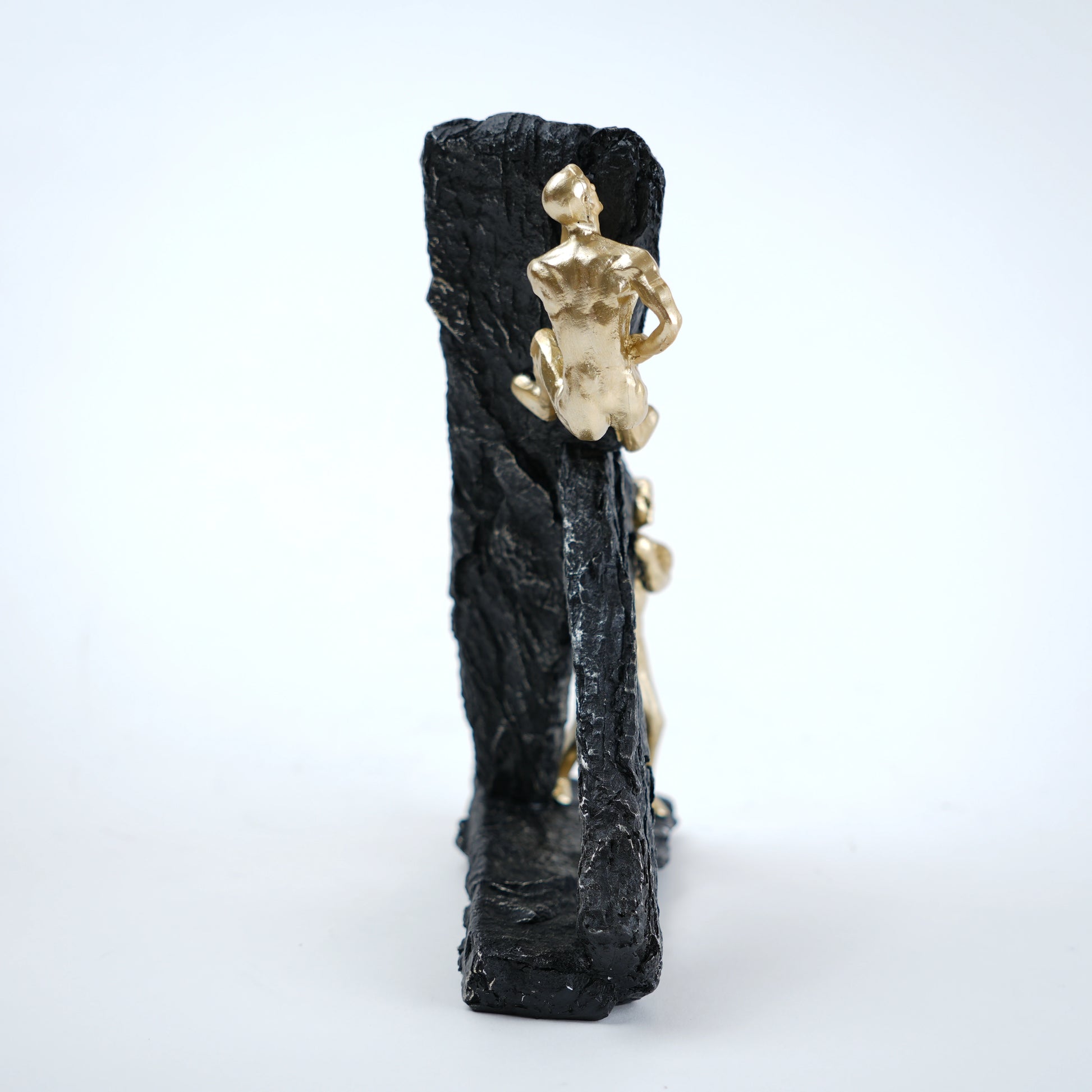 Decorative item with a gold figure on a black textured base against a white background
