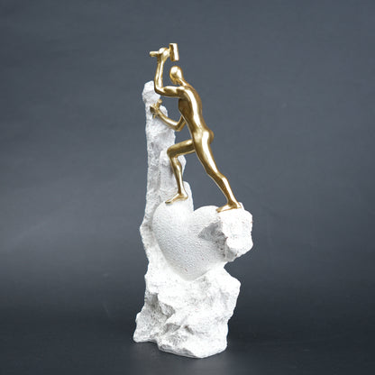 Teamwork climber figurine with gold figures pushing metallic sphere on textured rock base in black and white variants