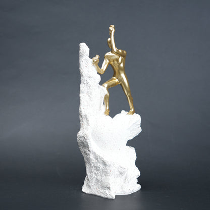 Teamwork climber figurine with gold figures pushing metallic sphere on textured rock base in black and white variants