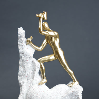 Teamwork climber figurine with gold figures pushing metallic sphere on textured rock base in black and white variants