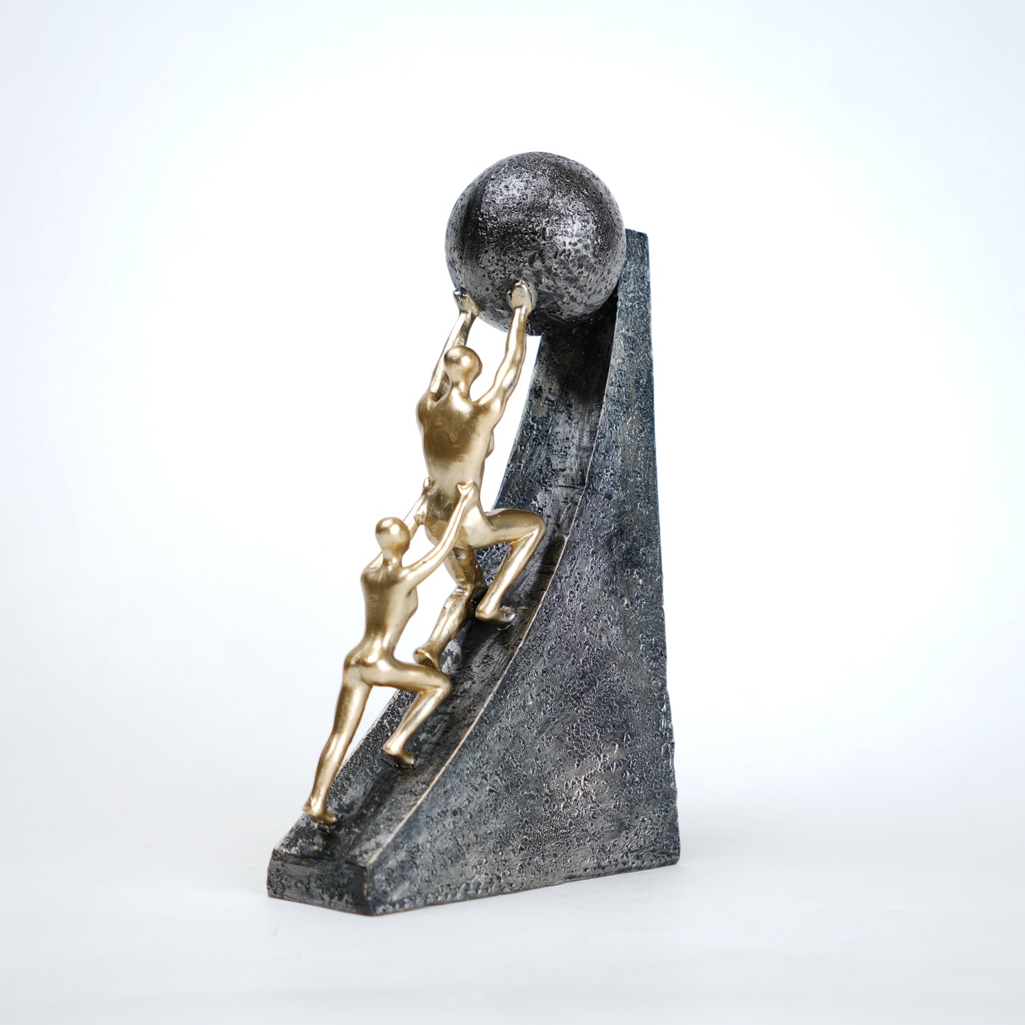 Mountain climber leadership sculpture with gold figurines guiding metallic sphere on textured stone base in black and white variants