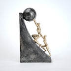 Mountain climber leadership sculpture with gold figurines guiding metallic sphere on textured stone base in black and white variants