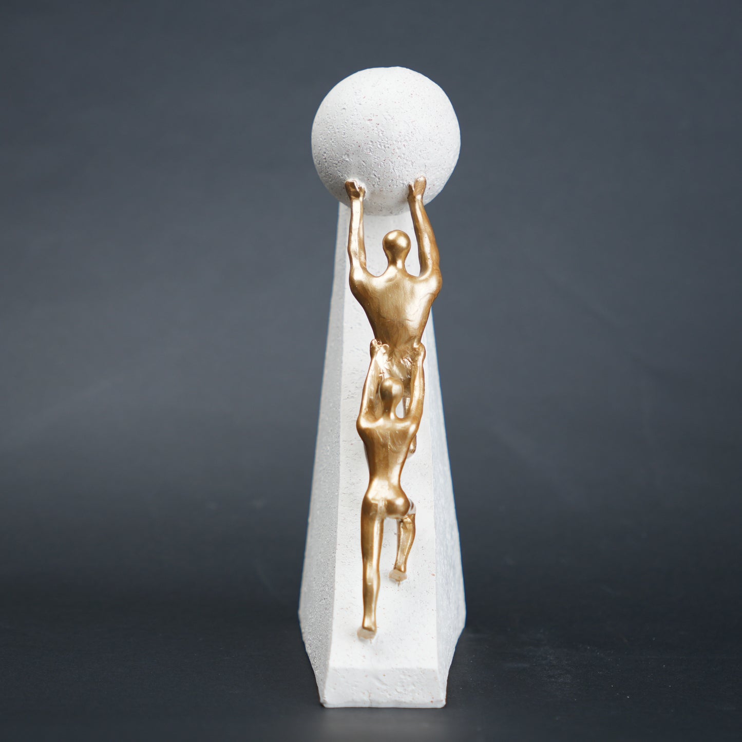 Mountain climber leadership sculpture with gold figurines guiding metallic sphere on textured stone base in black and white variants