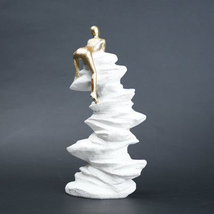 Mountain climber figurine with gold finish ascending layered stone base in black and white variants