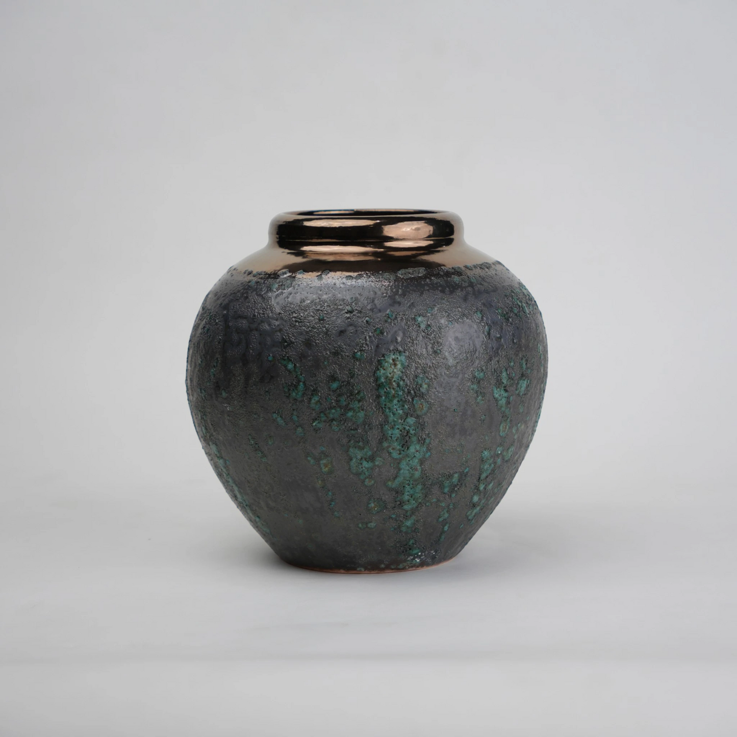 green charcoal ceramic vase with patina texture and bronze neck
