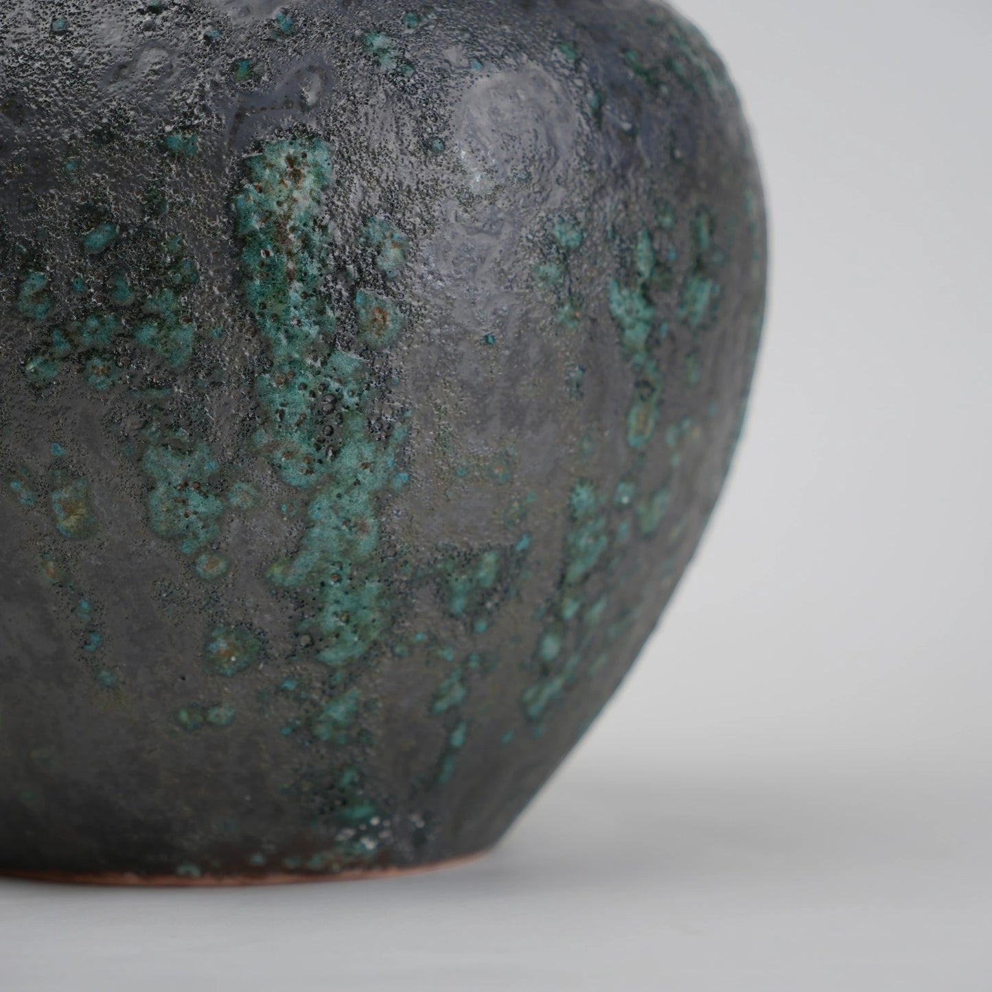 green charcoal ceramic vase with patina texture and bronze neck
