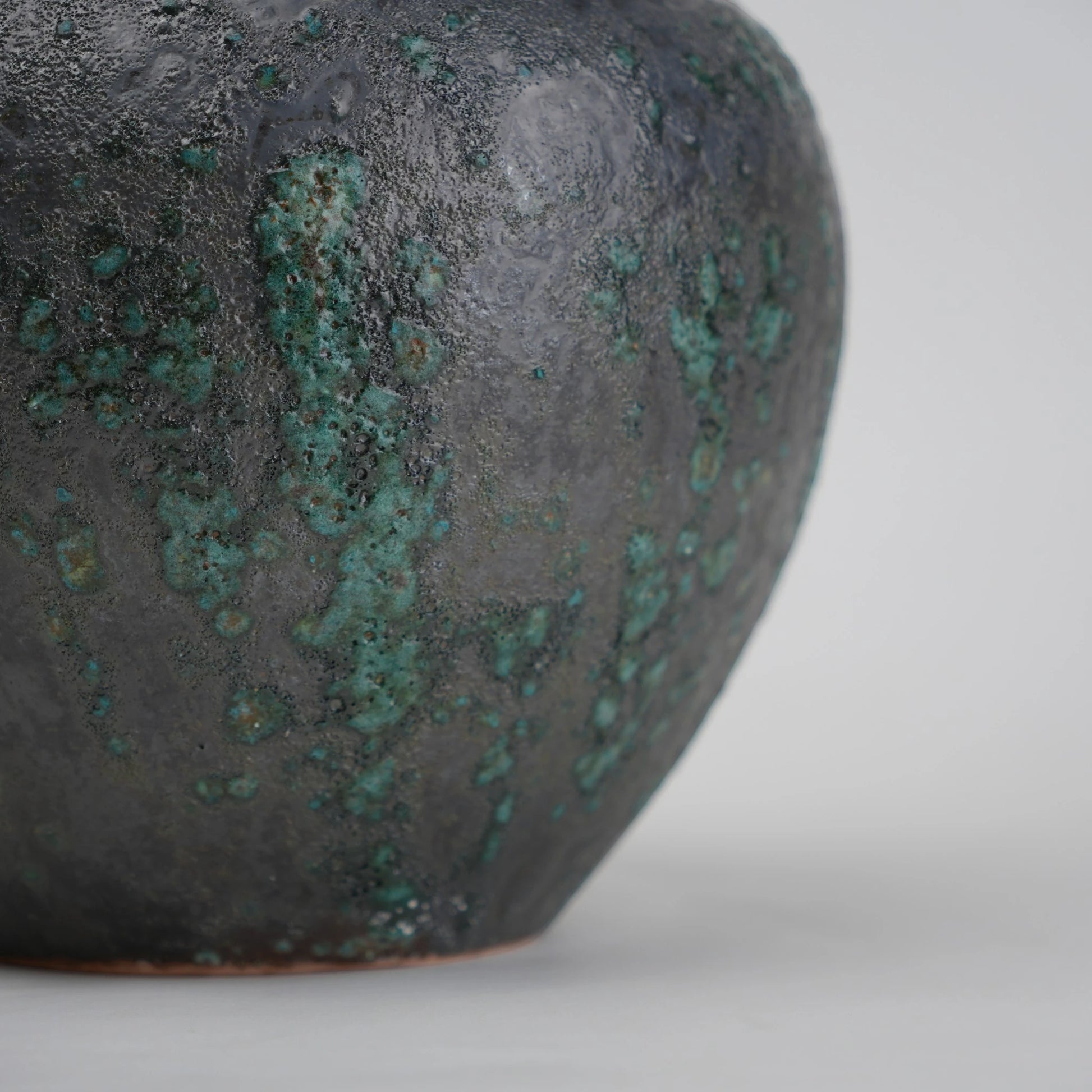 green charcoal ceramic vase with patina texture and bronze neck