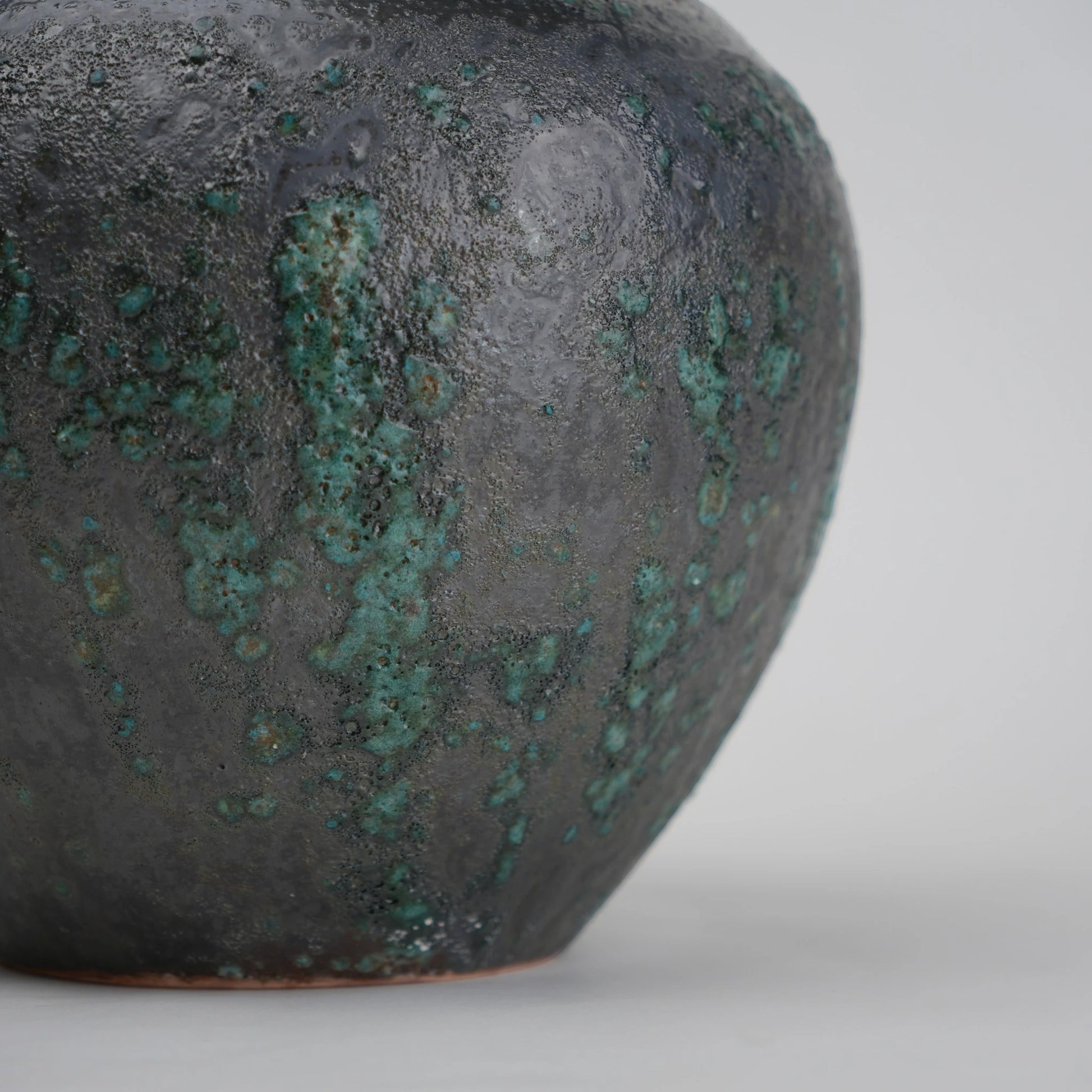 green charcoal ceramic vase with patina texture and bronze neck