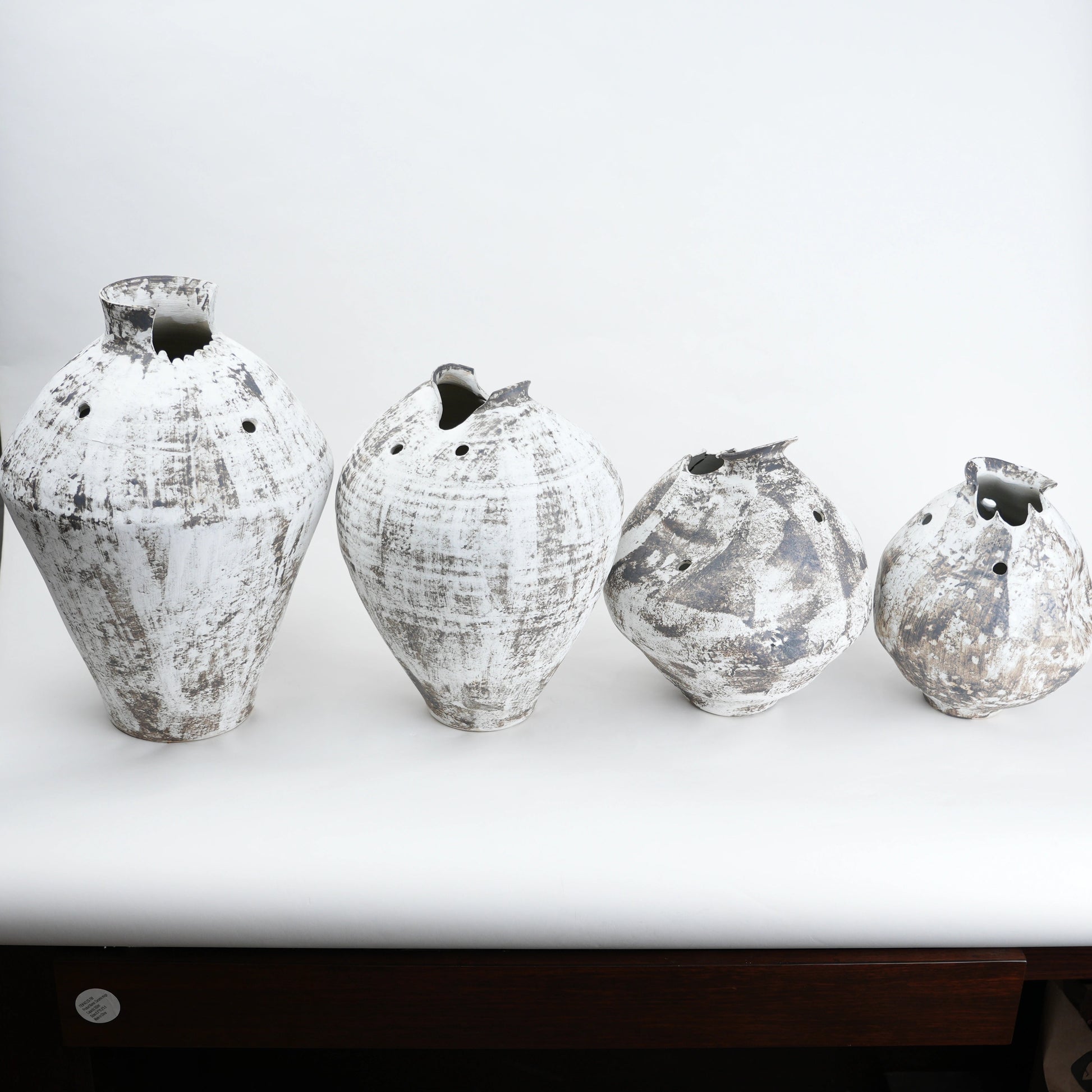 Four textured vases on a white surface
