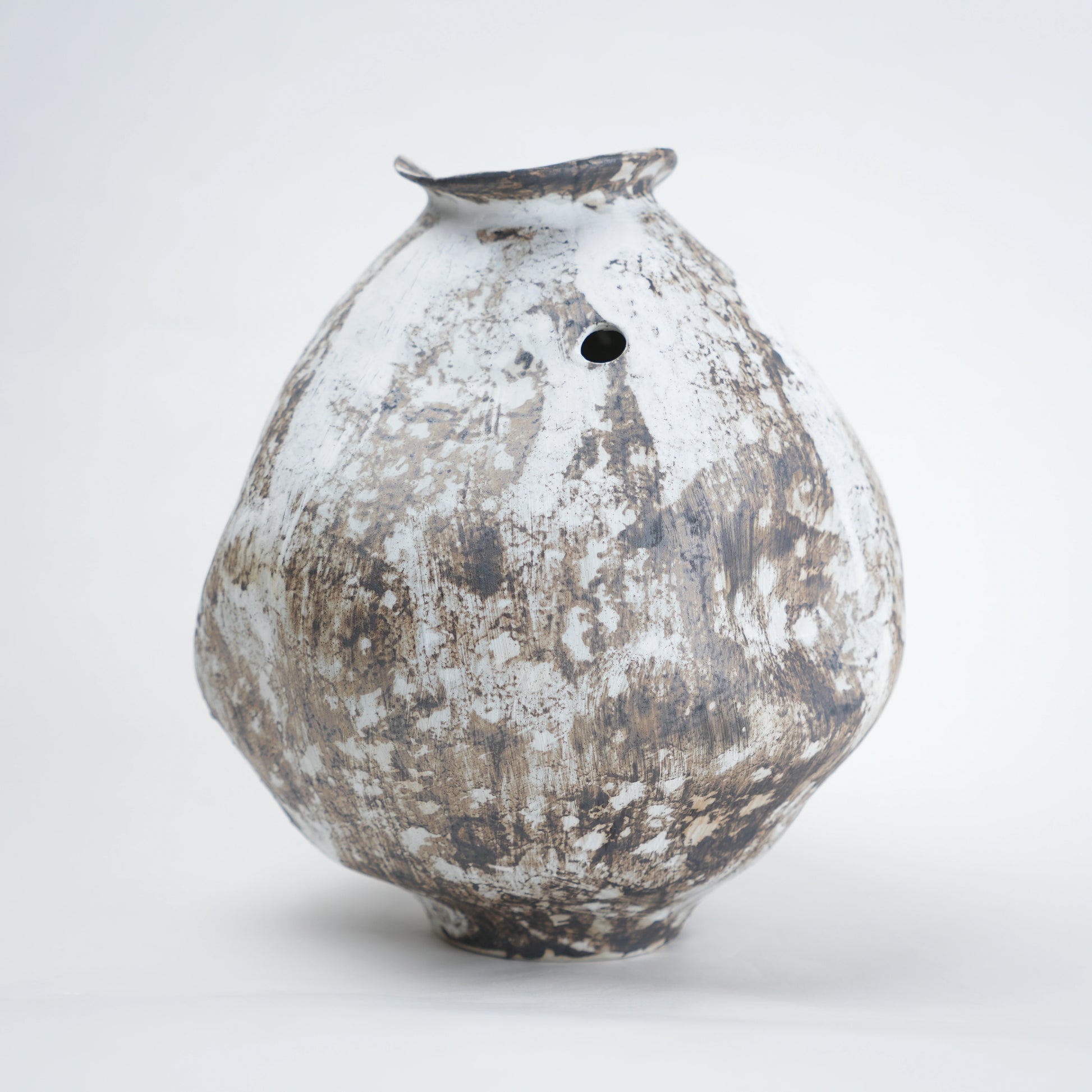 Vintage ceramic vase with a textured surface on a white background