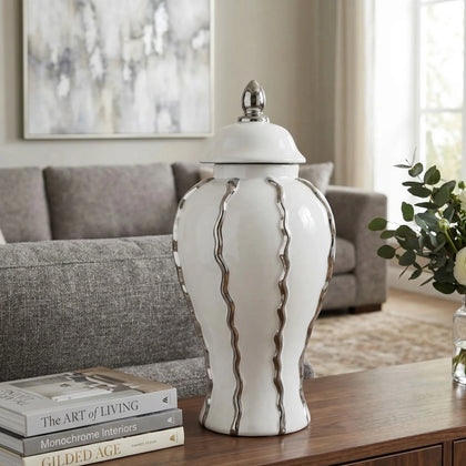 Ivory ceramic decorative jar with flowing metallic accents and lid