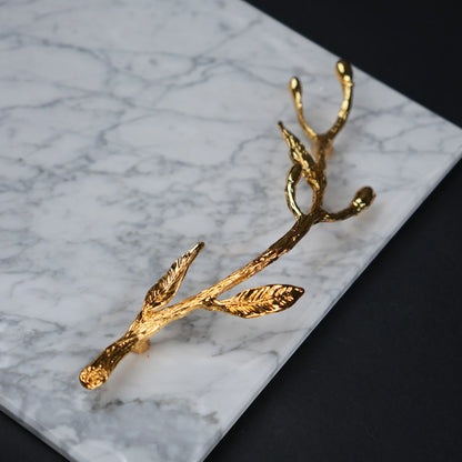White marble serving platter with gold branch handles for luxury dining and table styling