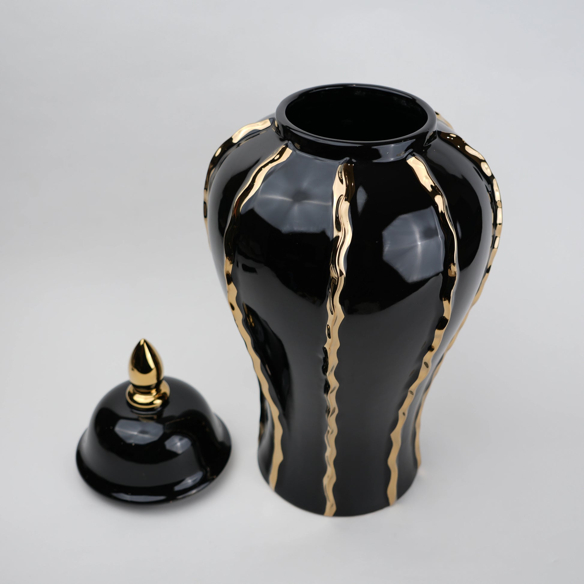 Black ceramic decorative jar with gold flowing accents and lid