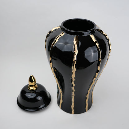 Black ceramic decorative jar with gold flowing accents and lid