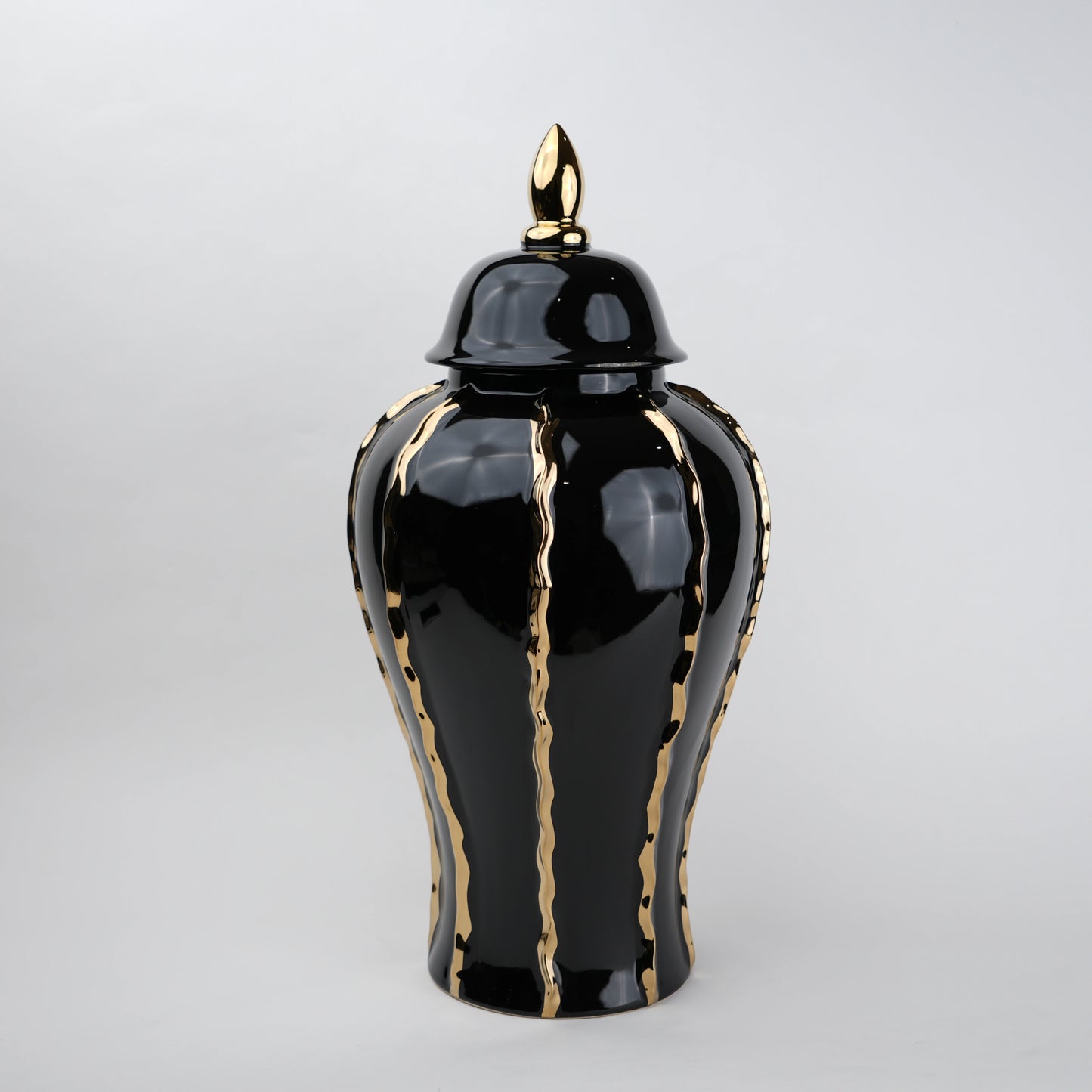 Black ceramic decorative jar with gold flowing accents and lid