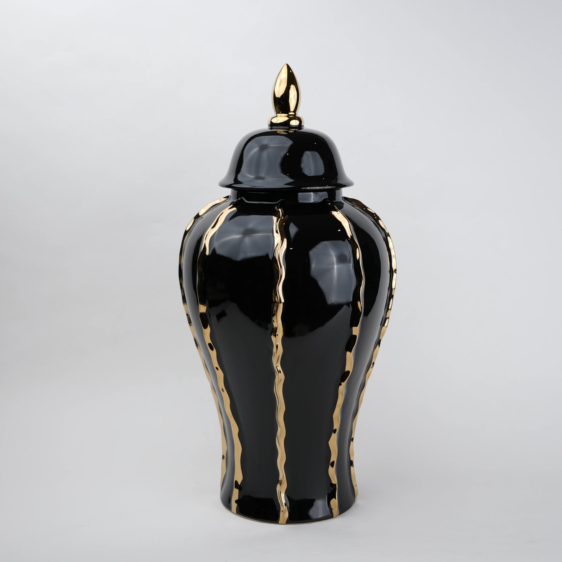 Black ceramic decorative jar with gold flowing accents and lid