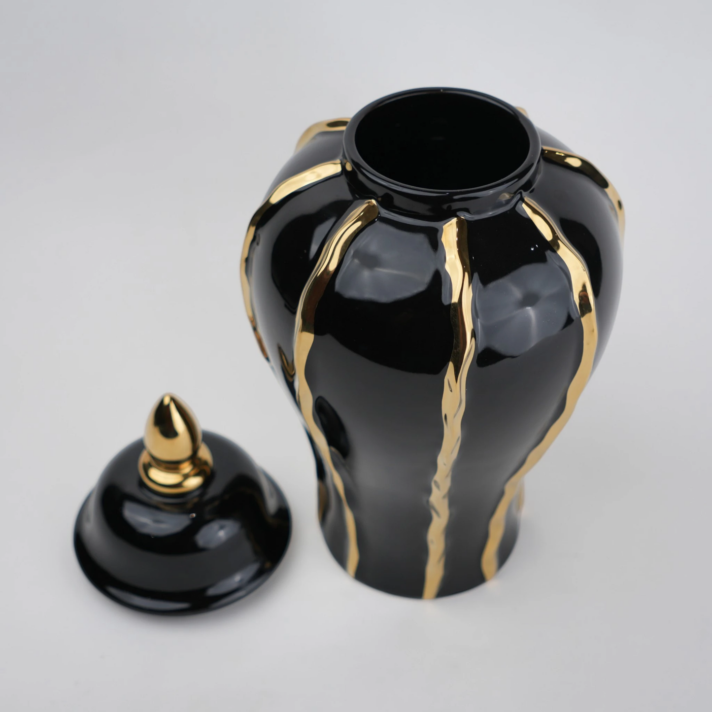Black ceramic decorative jar with gold flowing accents and lid