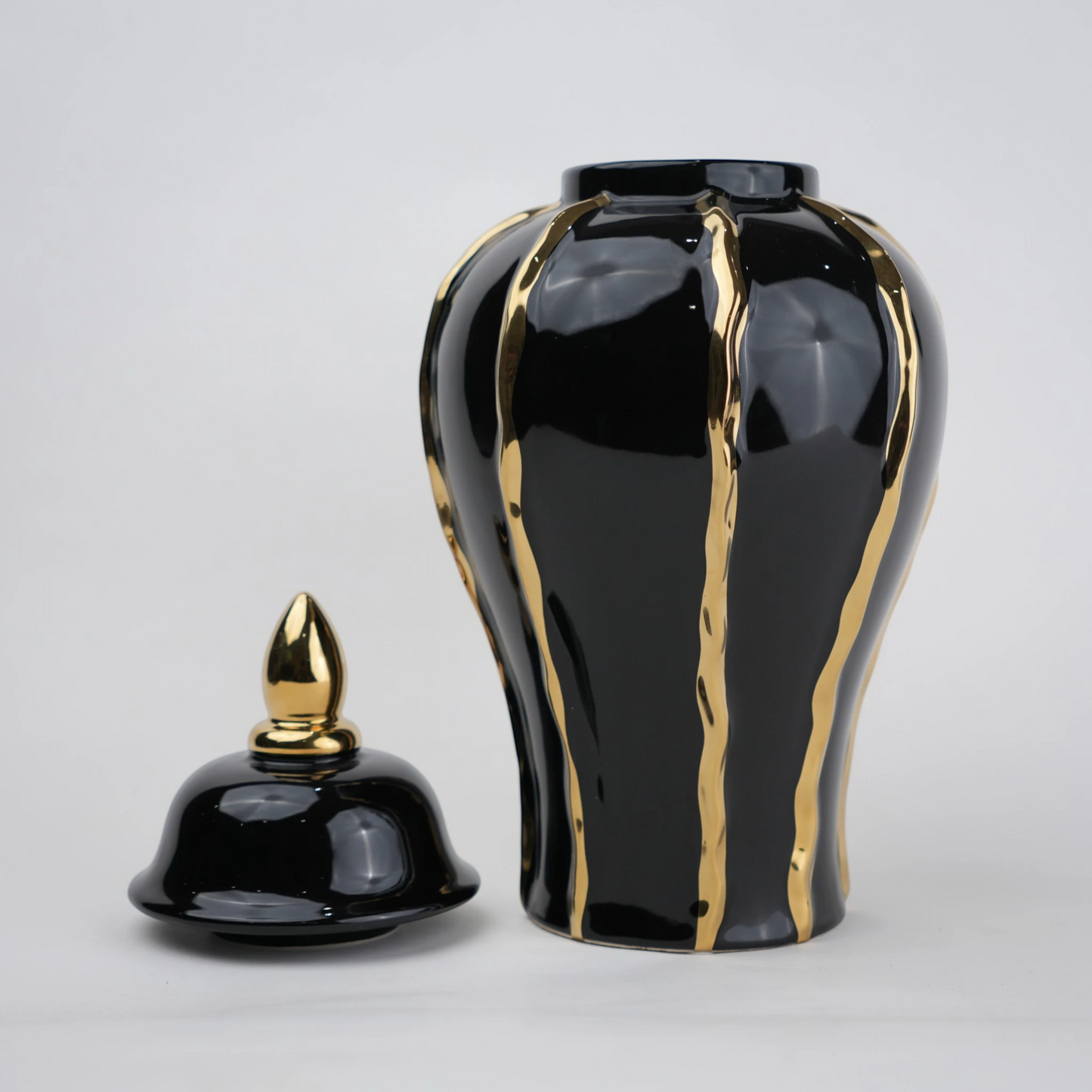 Black ceramic decorative jar with gold flowing accents and lid