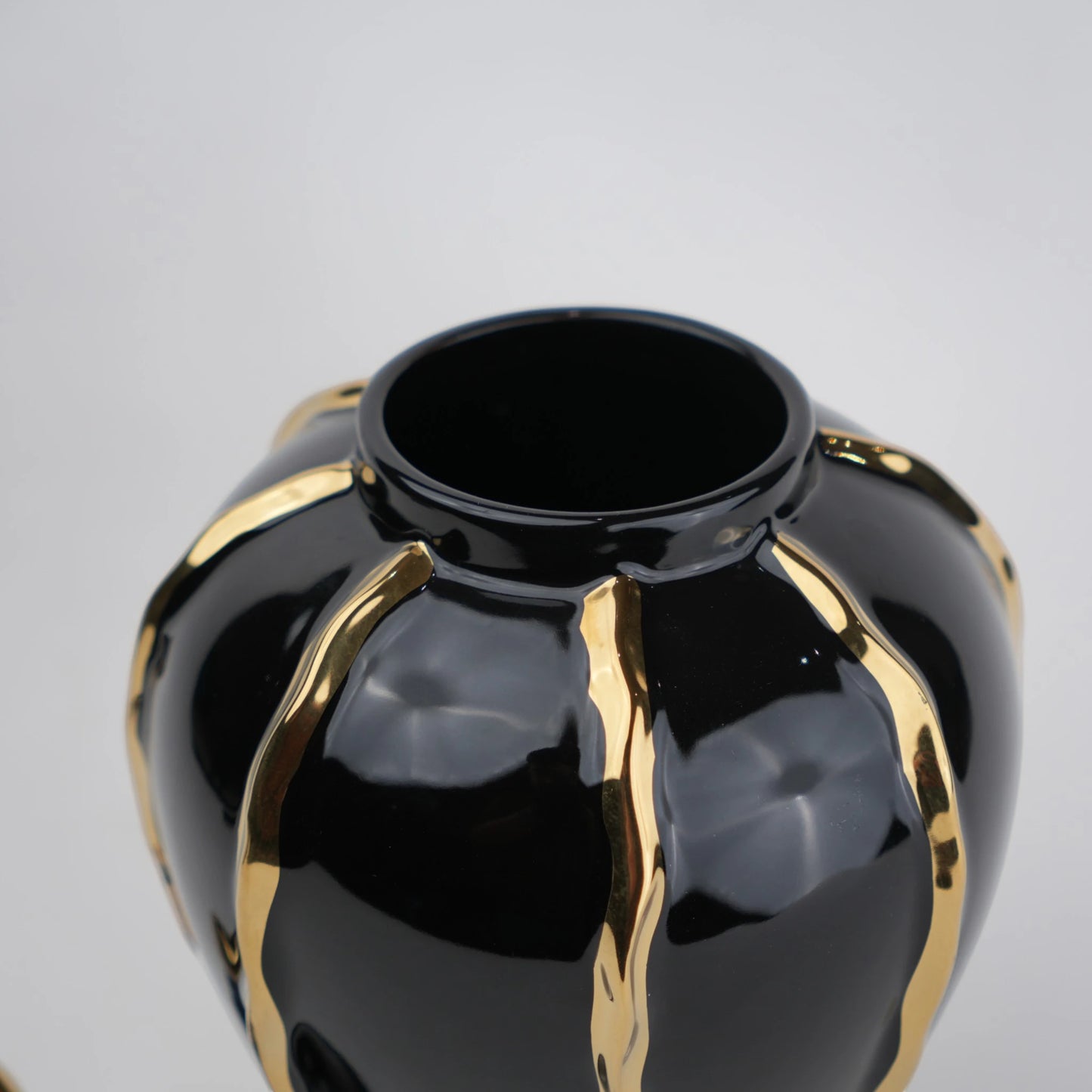 Black ceramic decorative jar with gold flowing accents and lid