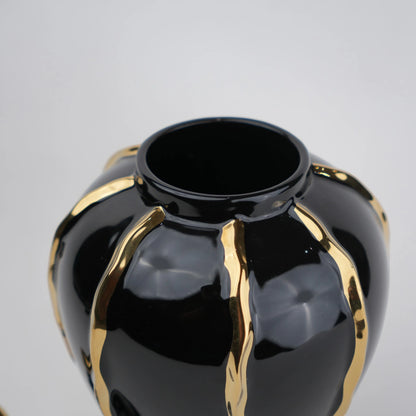 Black ceramic decorative jar with gold flowing accents and lid
