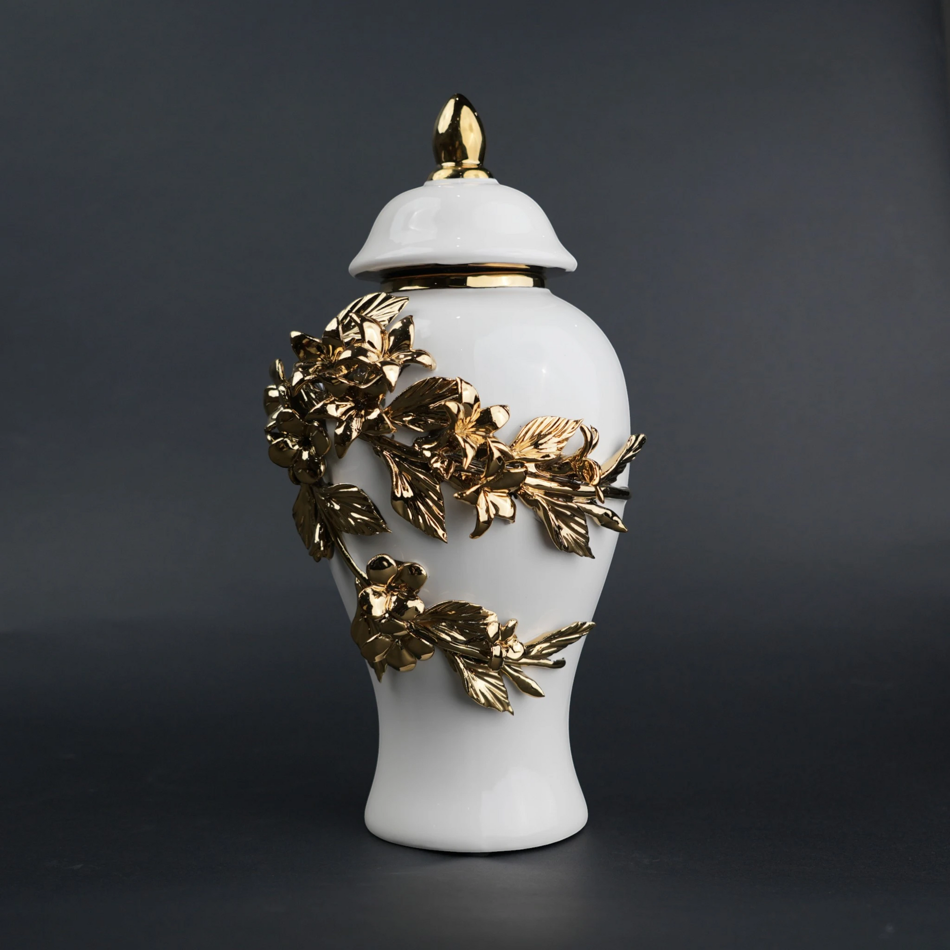 White ceramic decorative jar with sculpted gold floral design and lid