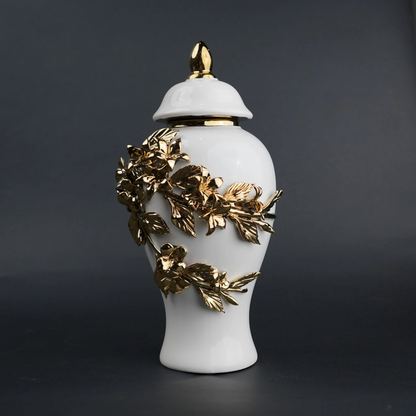 White ceramic decorative jar with sculpted gold floral design and lid