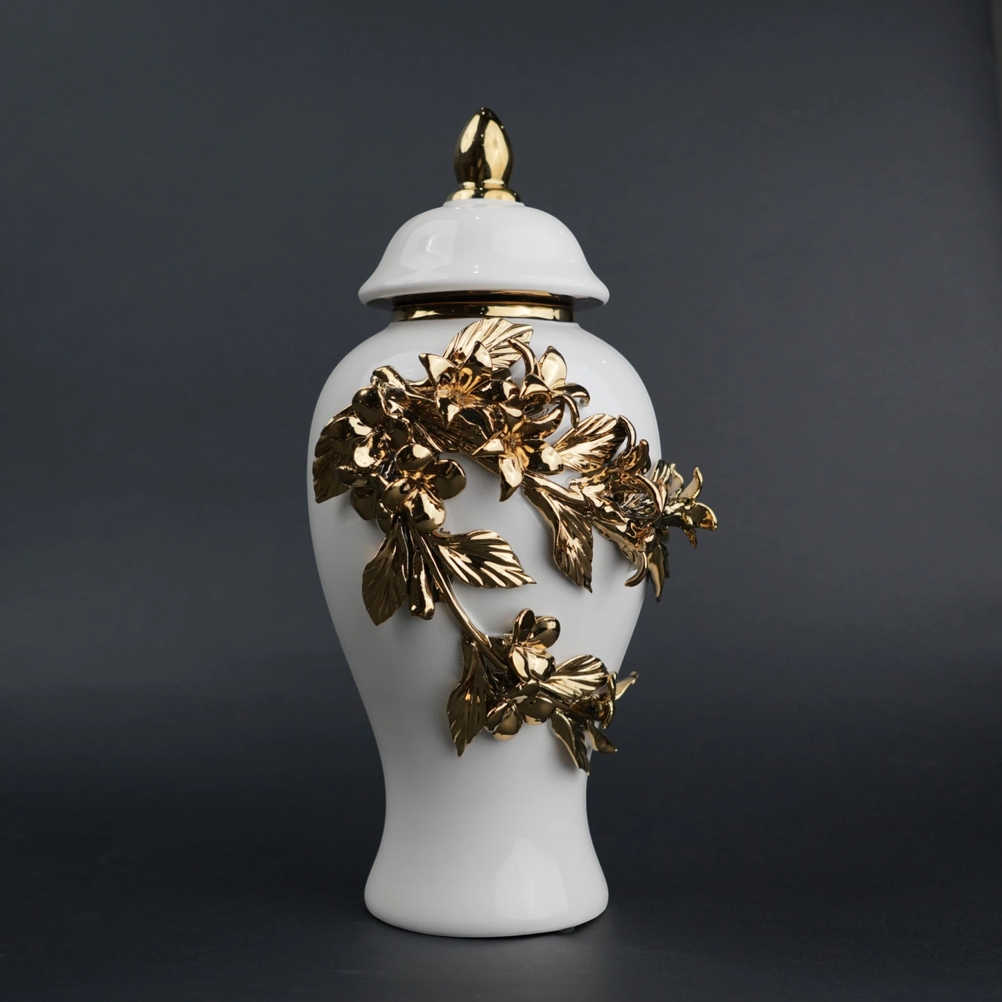 White ceramic decorative jar with sculpted gold floral design and lid