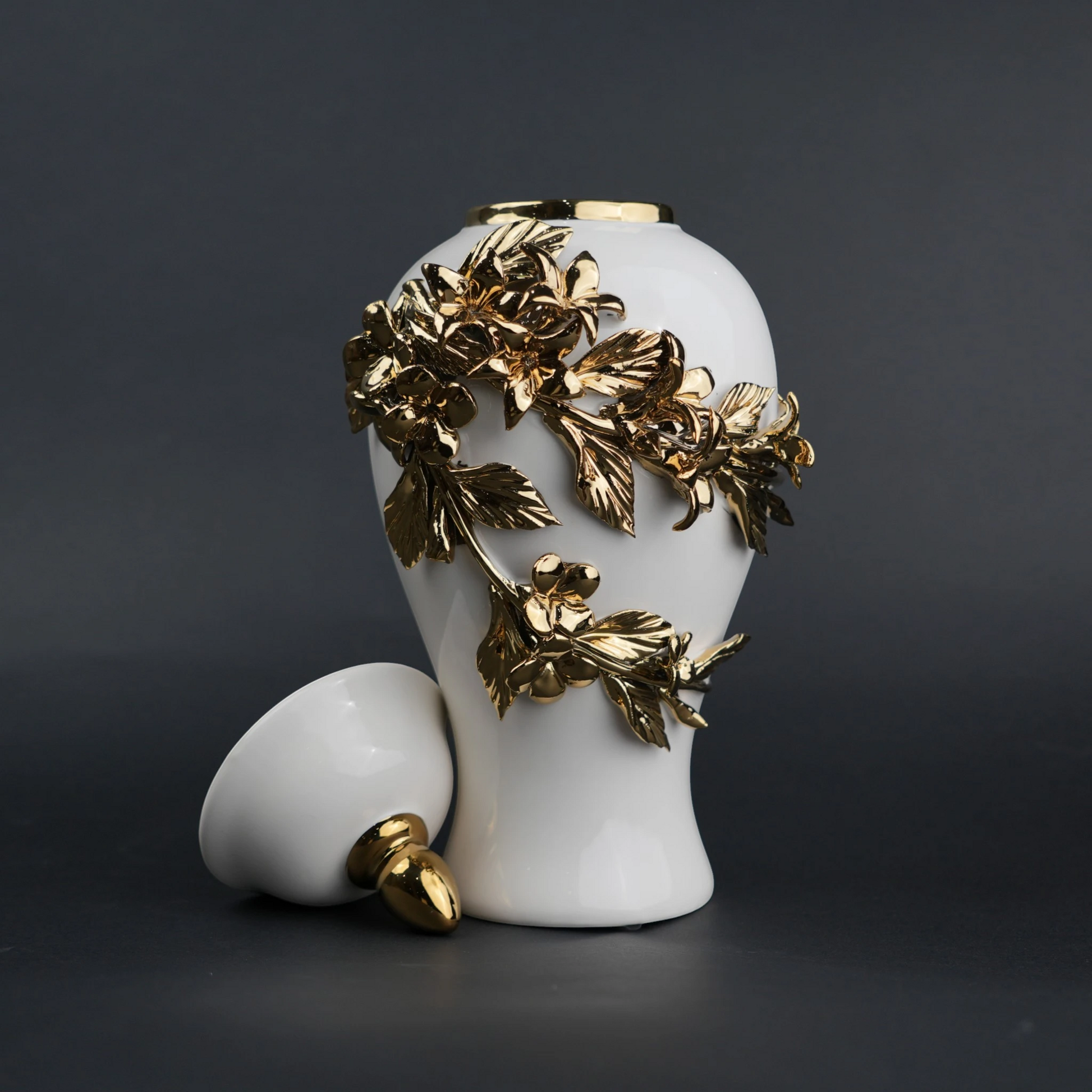 White ceramic decorative jar with sculpted gold floral design and lid
