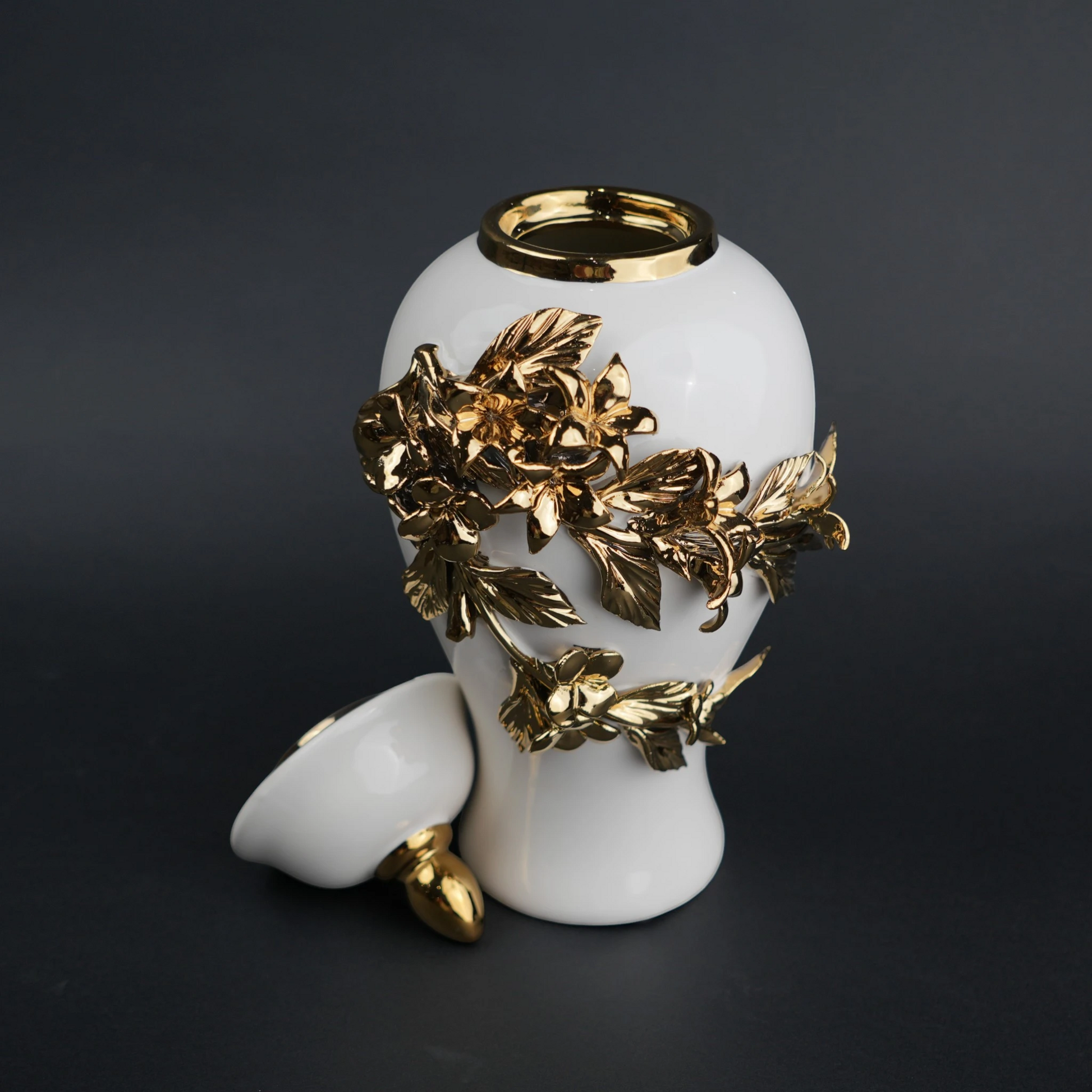 White ceramic decorative jar with sculpted gold floral design and lid