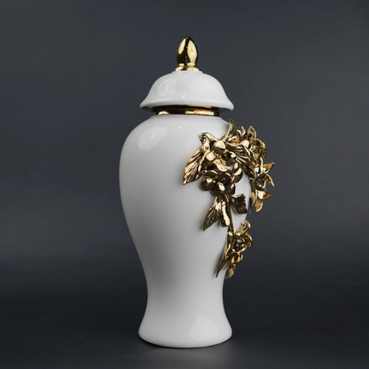 White ceramic decorative jar with sculpted gold floral design and lid