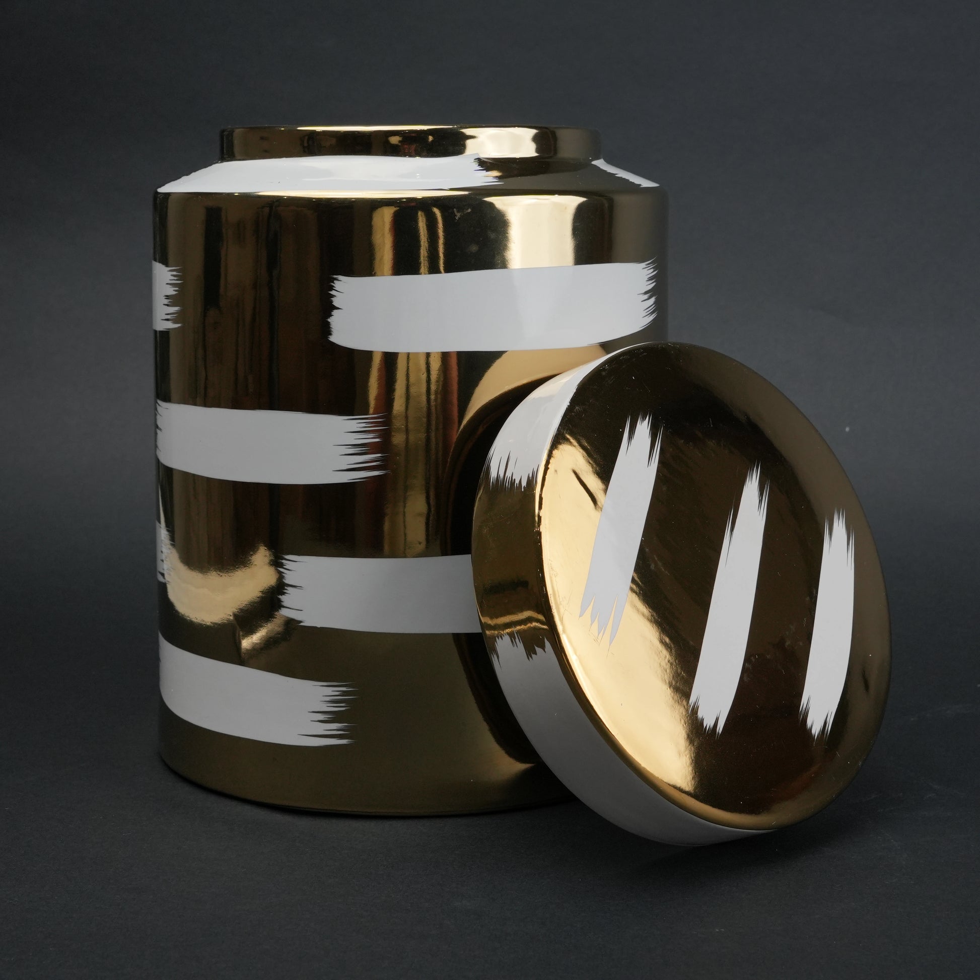 Golden stroke jar on charcoal, lid at side