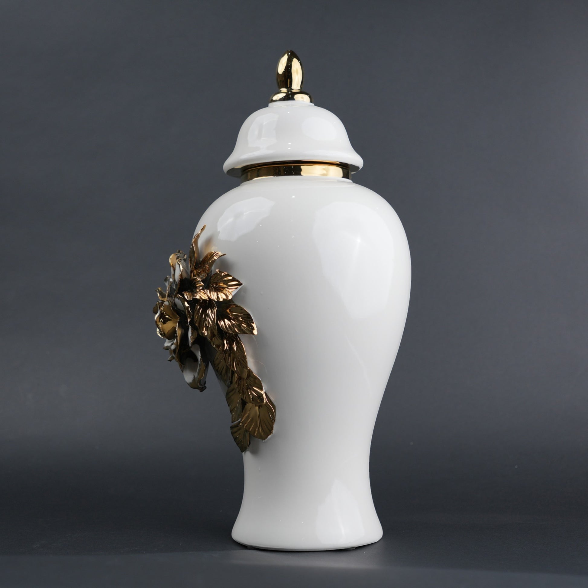 White ceramic jar with gold leaf design and lid on a